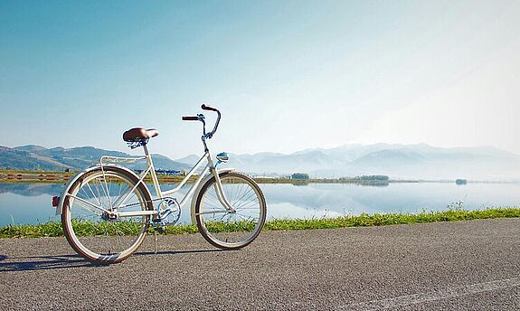Fahrrad Ein Fahrrad steht geparkt an einem See.